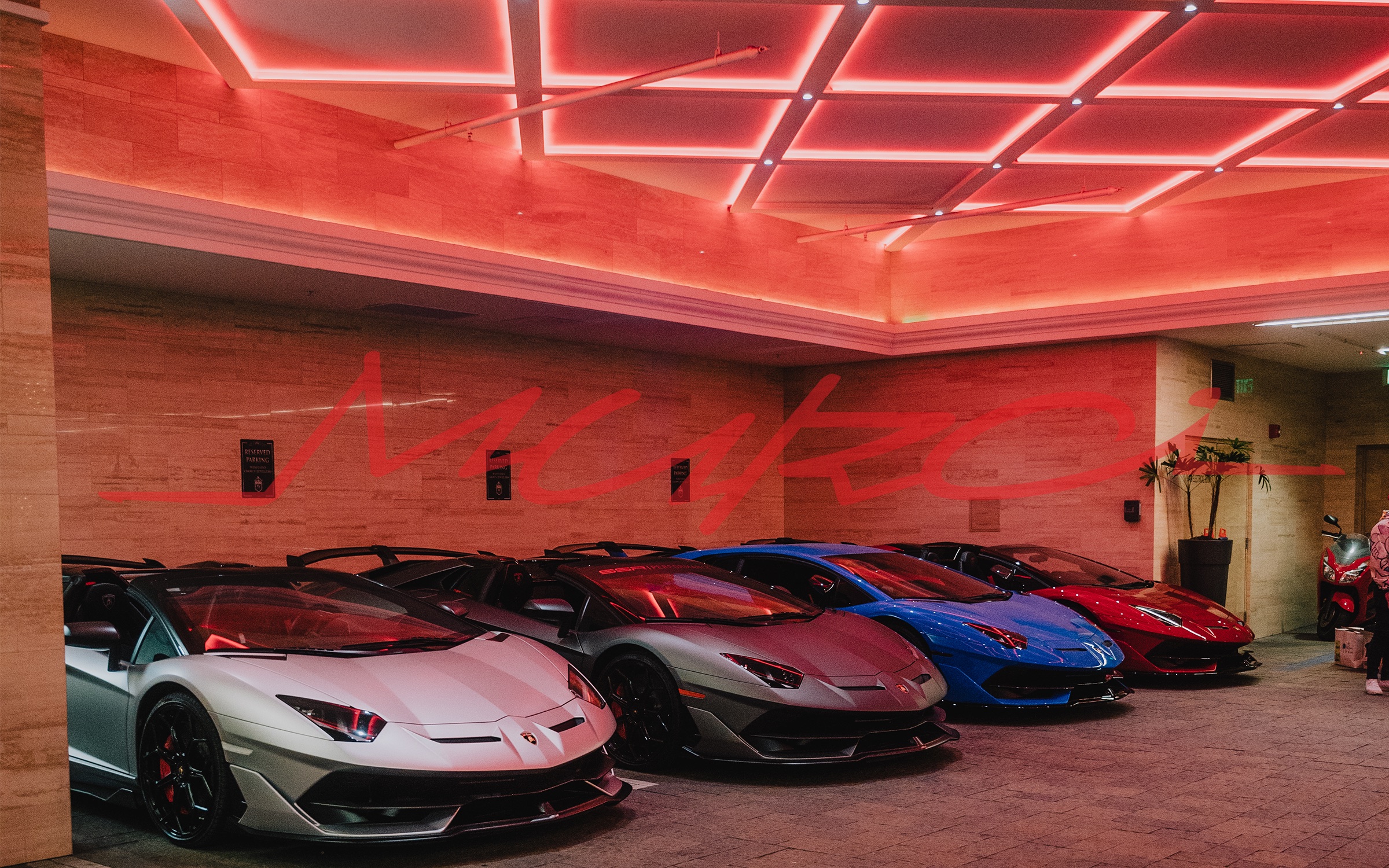 Lamborghini lineup under red neon at a MURCI'S REVENGE event